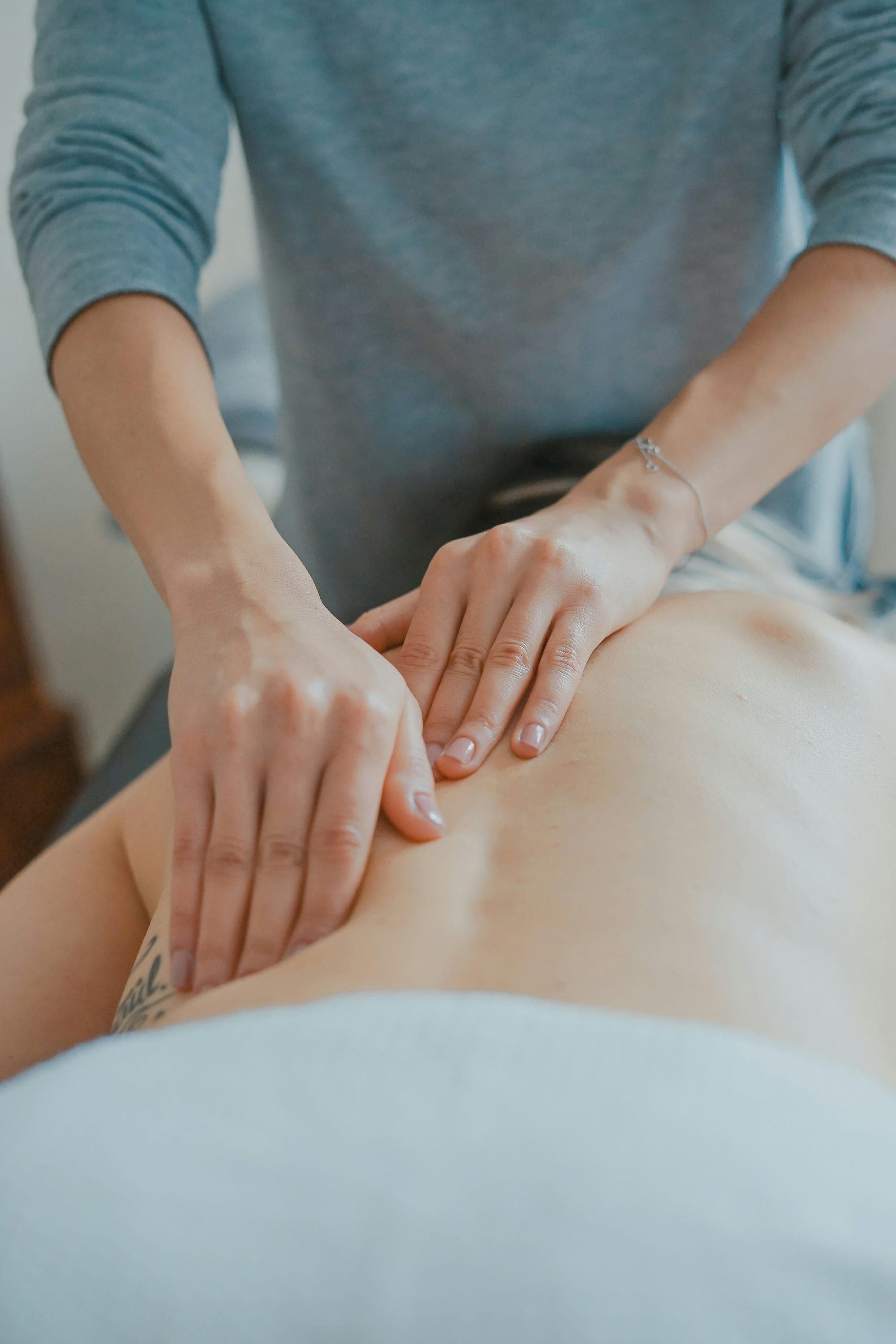 Spa therapist performing a back massage on a relaxed client in a wellness treatment room