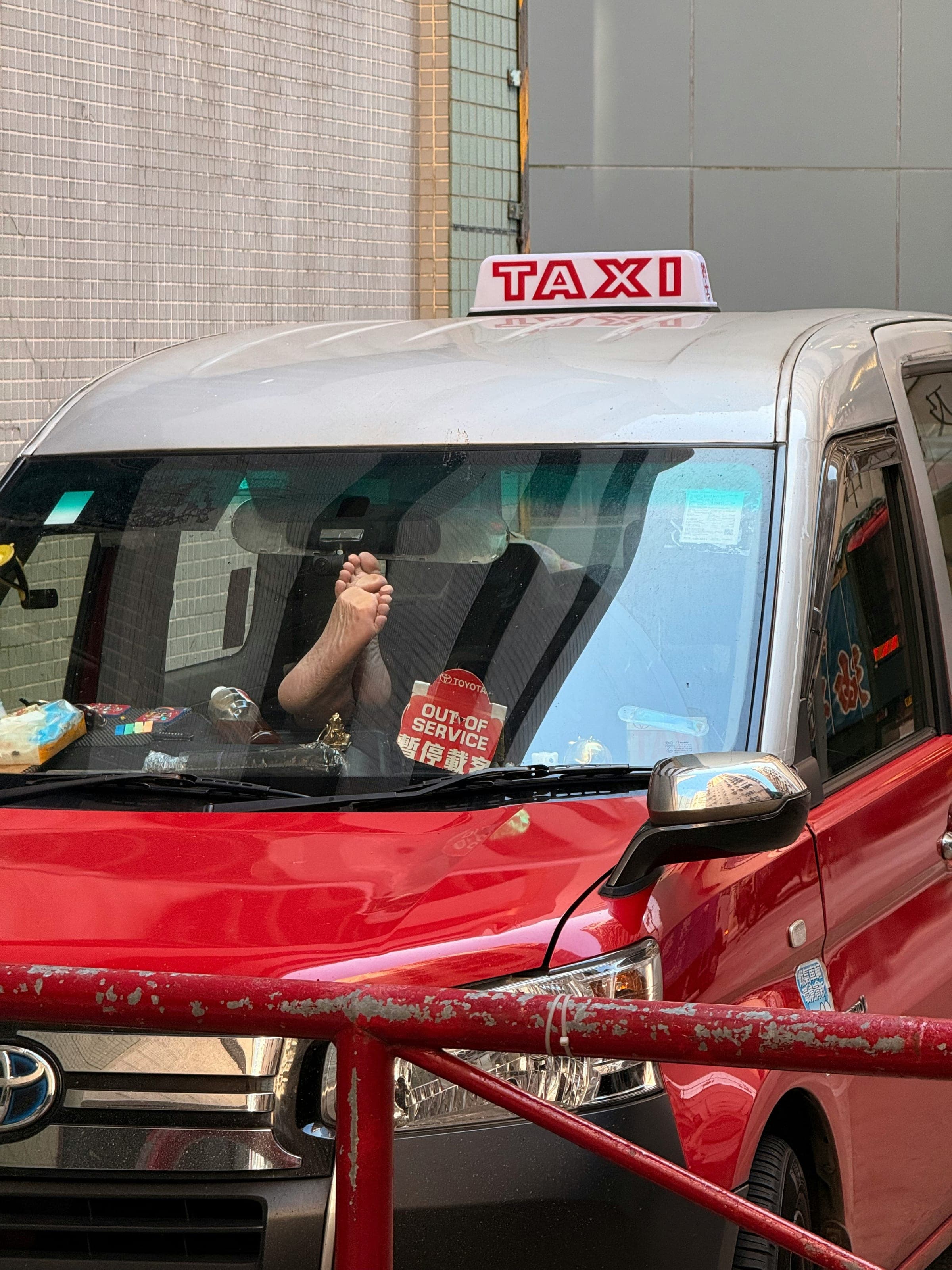 Close-up of a taxi driver's hands clasped on the steering wheel while driving