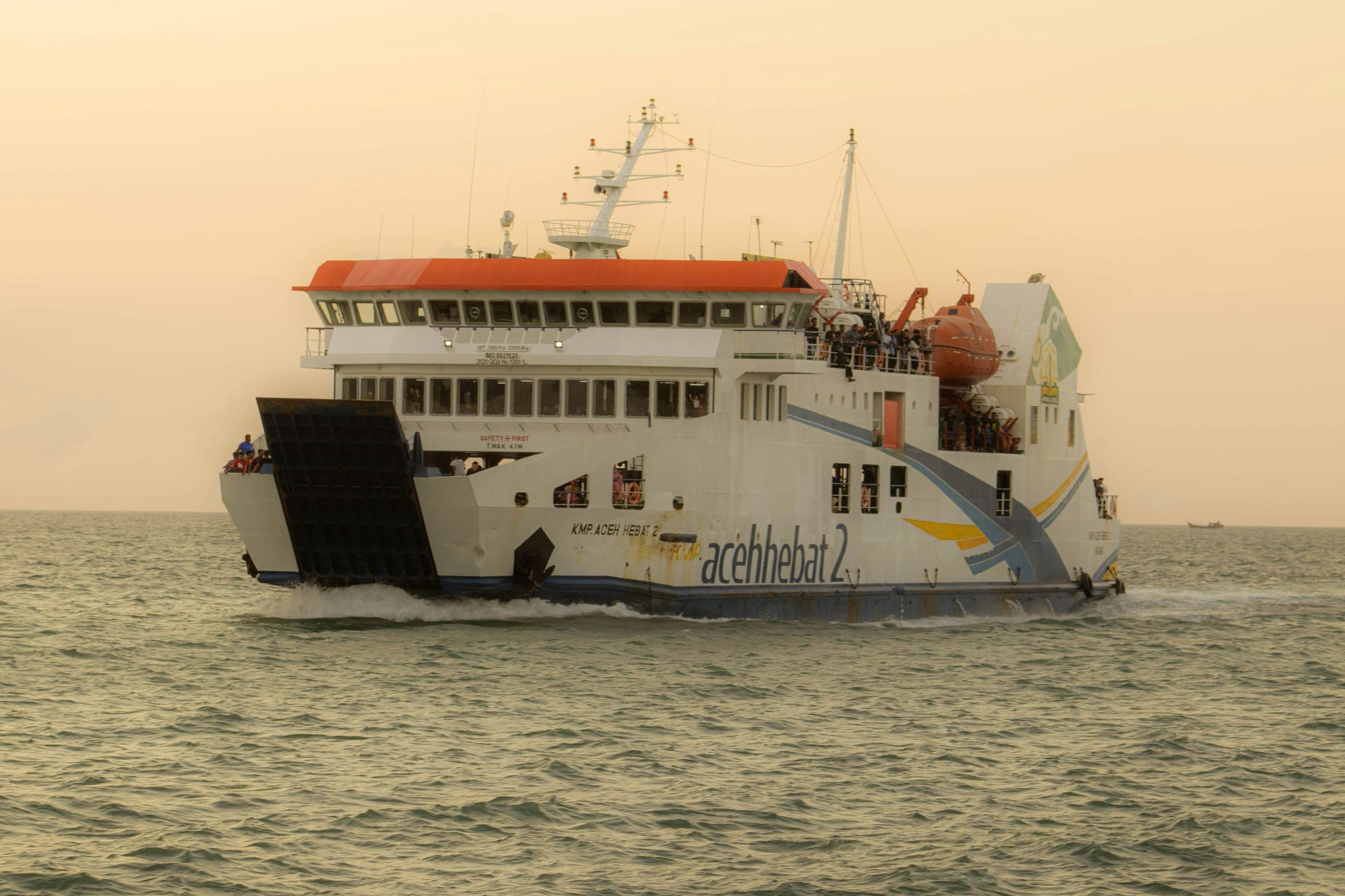 Large passenger ferry sailing across open water at golden hour
